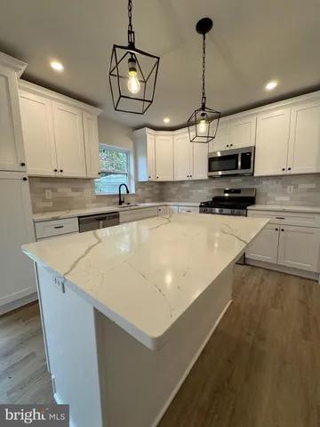 a kitchen with kitchen island a counter top space appliances and cabinets