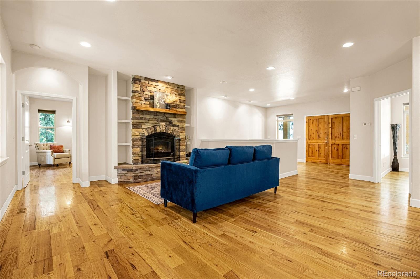 4775 Neeper Valley Road Manitou Springs, CO 80829 - Photo 5 of 41 a living room with furniture wooden floor and a fireplace