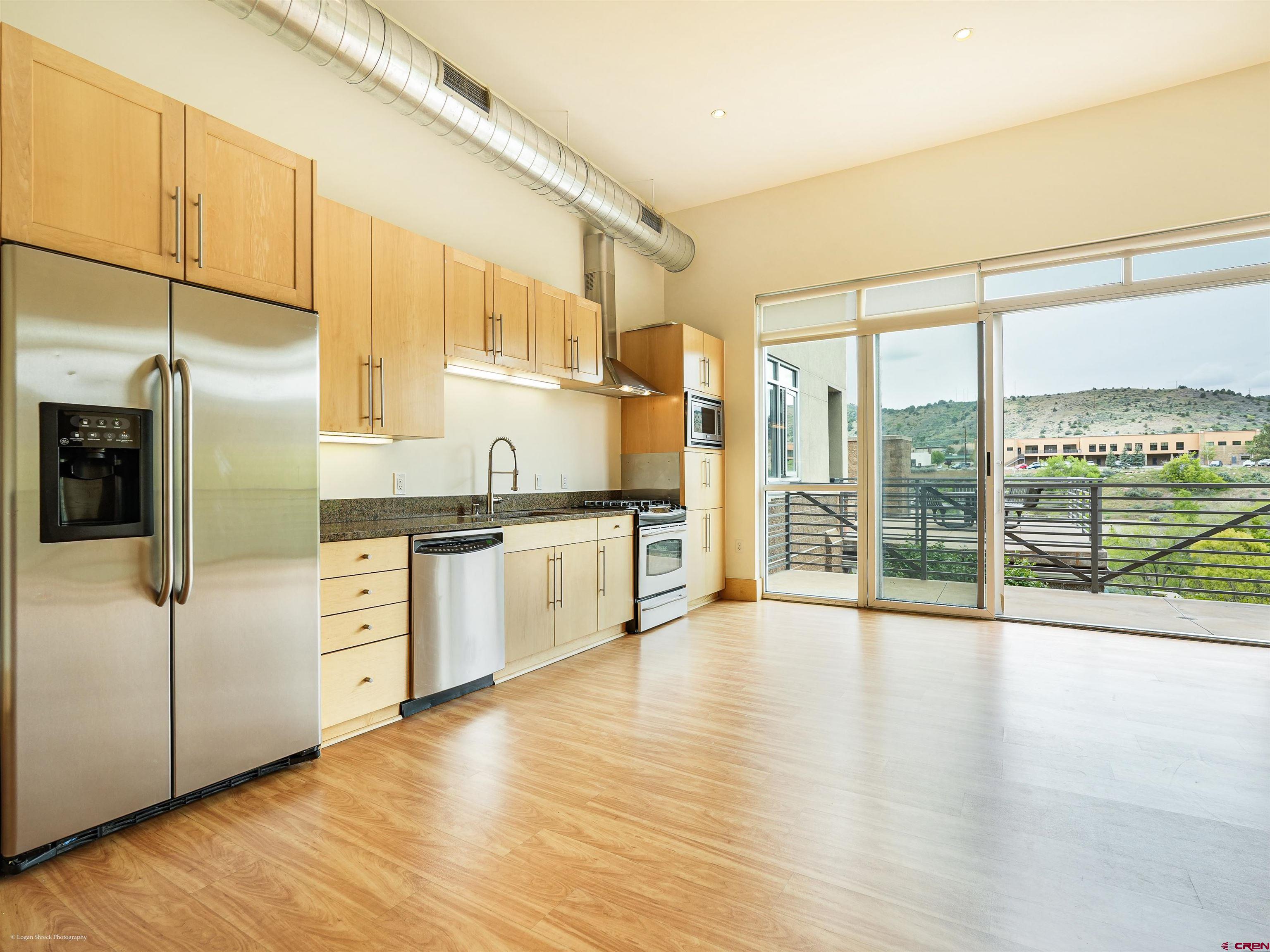 555 Rivergate Lane, Unit B2139 Durango, CO 81301 - Photo 13 of 32 a kitchen with stainless steel appliances granite countertop a refrigerator a sink and white cabinets with wooden floor