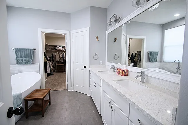 a spacious bedroom with a bed and a dresser