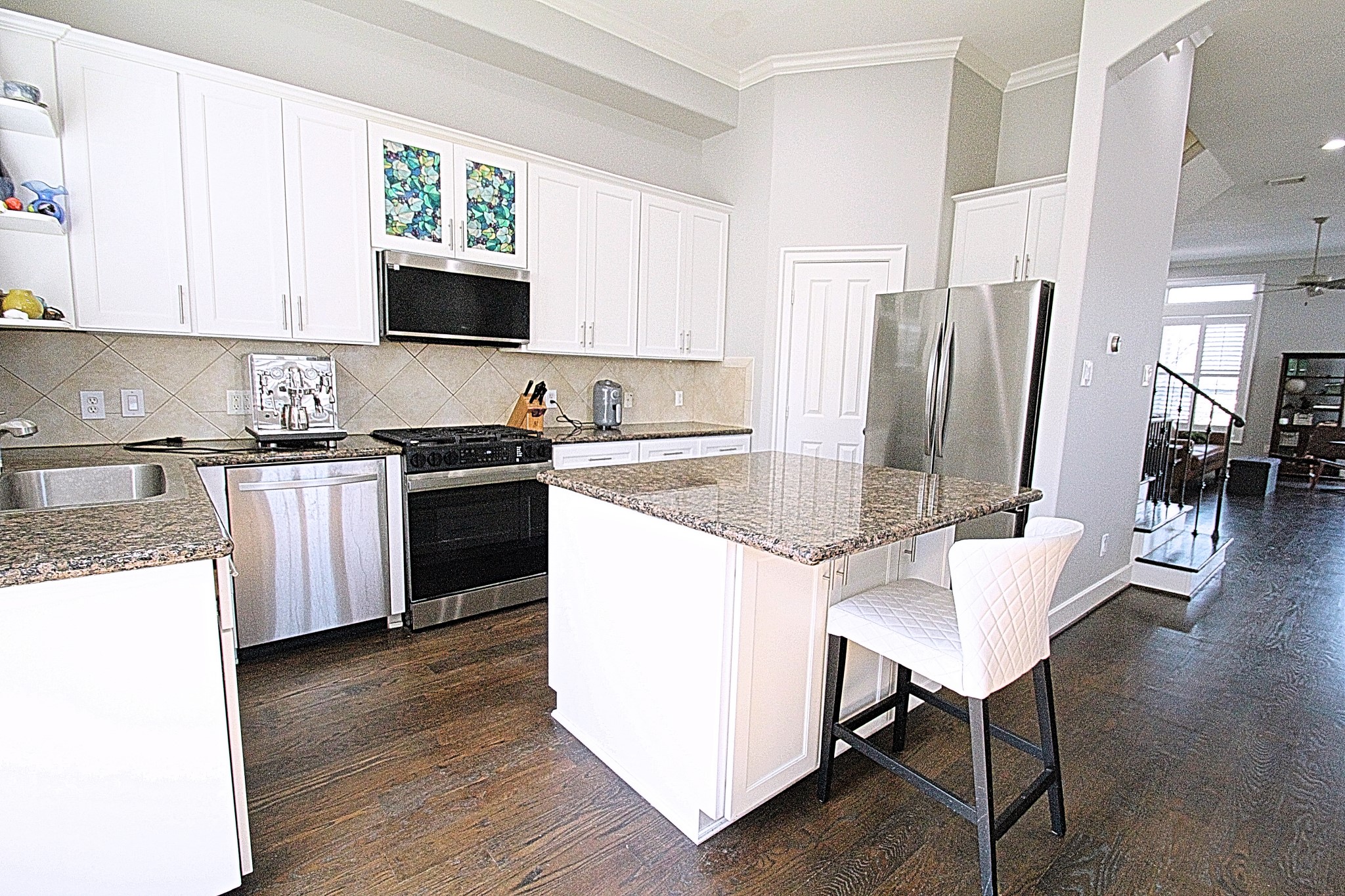 1317 Bomar Street Houston, TX 77006 - Photo 7 of 27 a kitchen with stainless steel appliances granite countertop a stove a sink dishwasher a refrigerator and a dining table with wooden floor