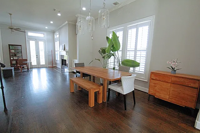 a kitchen with stainless steel appliances granite countertop a stove a sink dishwasher a refrigerator and a dining table with wooden floor