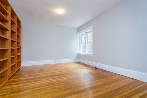 96 Naples Road, Unit 6 Brookline, MA 02446 - Photo 8 of 14 a view of an empty room with wooden floor and a window