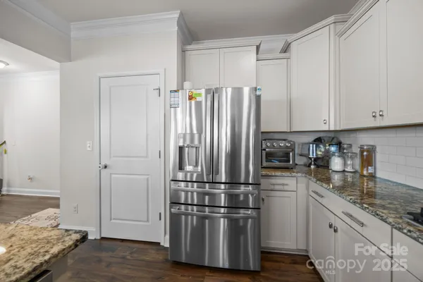 a kitchen with stainless steel appliances granite countertop a refrigerator and a sink
