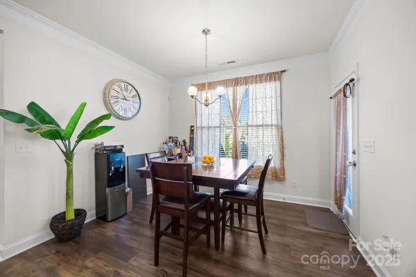 a view of a dining room and livingroom with furniture wooden floor and a window