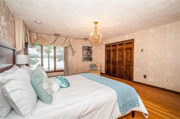2 Lakeshore Drive Wakefield, MA 01880 - Photo 12 of 29 a spacious bedroom with a bed and a chandelier