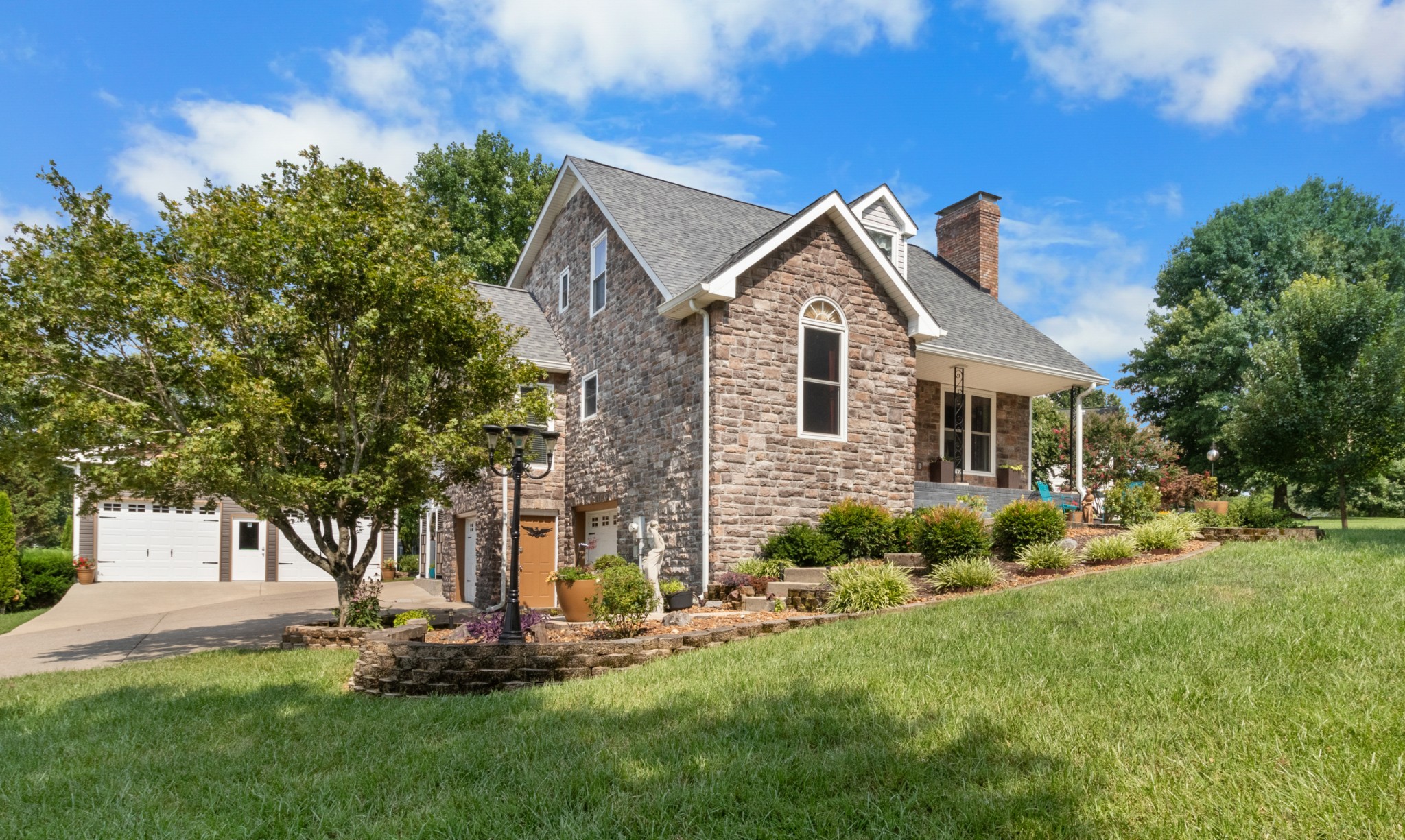 901 Riverchase Road Adams, TN 37010 - Photo 5 of 35 a front view of a house with a garden and trees