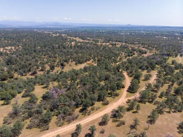 a view of a dry yard with mountains in the background