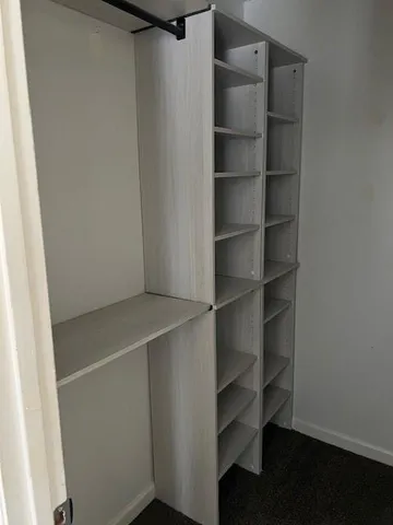 a view of walk in closet with empty racks