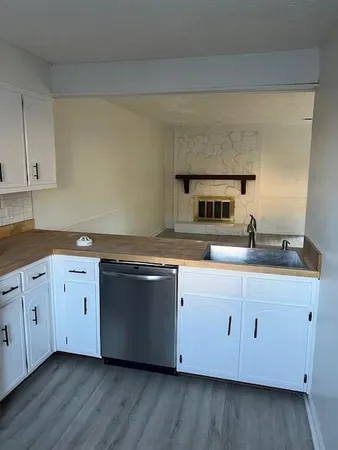 a kitchen with stainless steel appliances granite countertop a sink and dishwasher with wooden floor