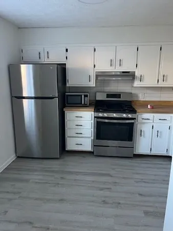 a kitchen with a refrigerator stove and white cabinets