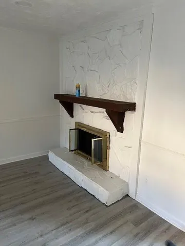 a living room with a fireplace and wooden floor