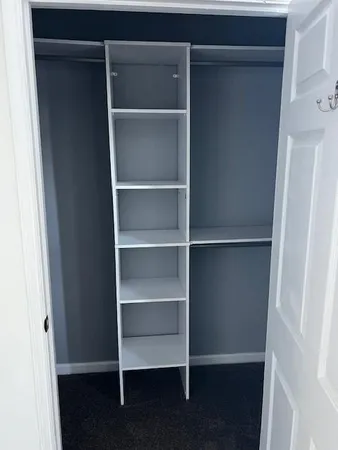 a view of walk in closet with empty racks
