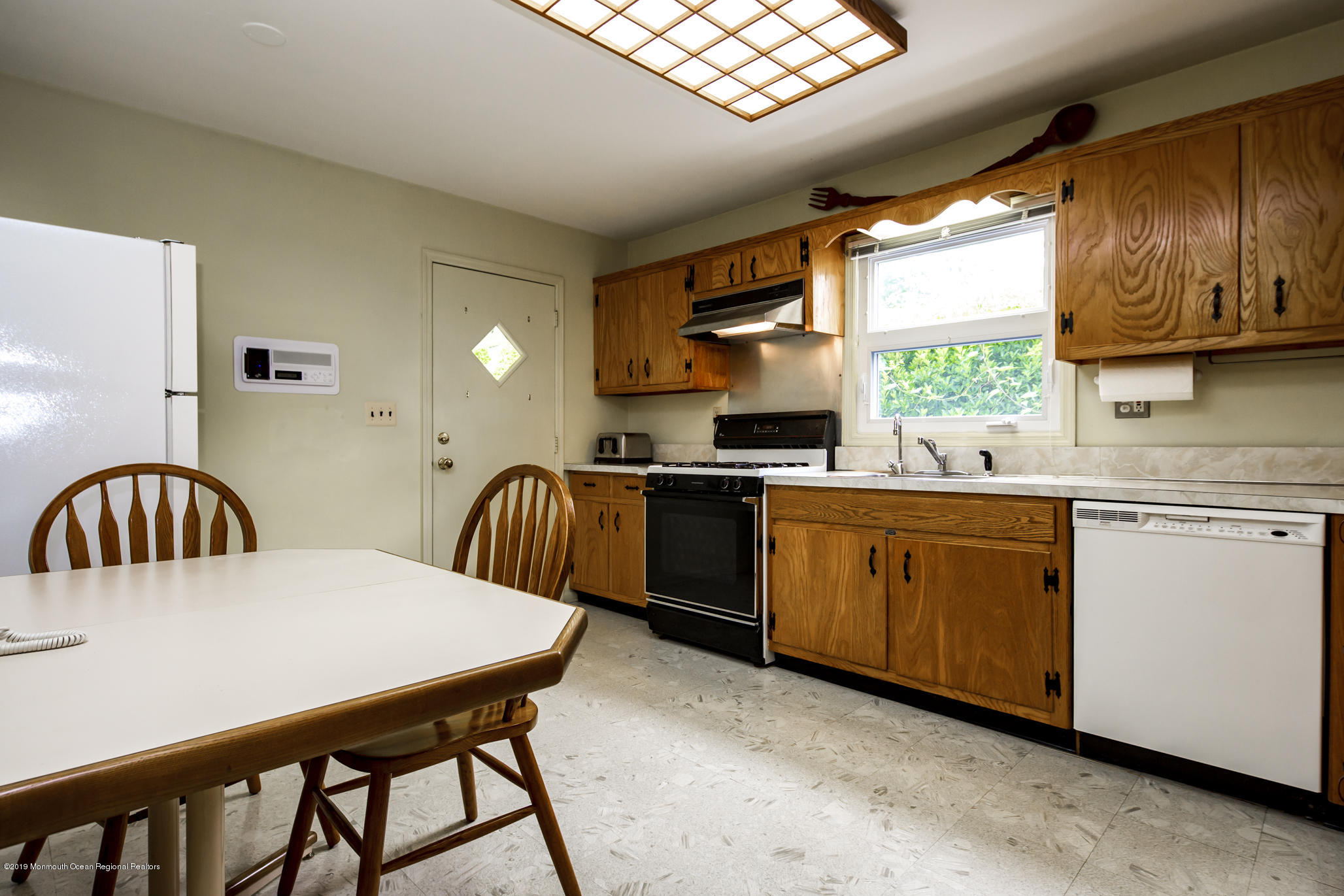 503 Wildwood Road West Allenhurst, NJ 07711 - Photo 6 of 26 a kitchen with granite countertop a stove a sink a dining table and chairs