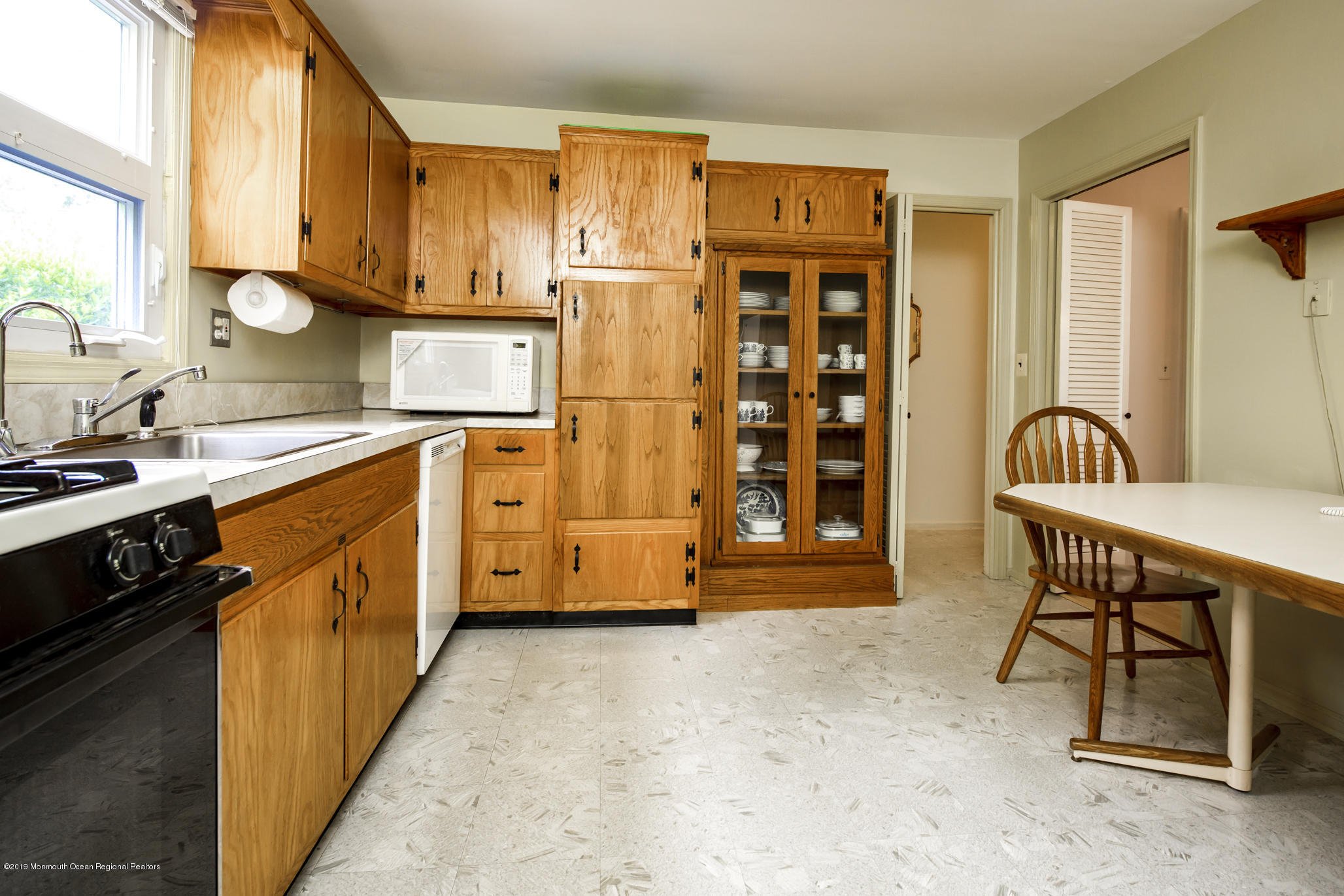 503 Wildwood Road West Allenhurst, NJ 07711 - Photo 8 of 26 a kitchen with stainless steel appliances a stove a sink and a refrigerator with wooden cabinets