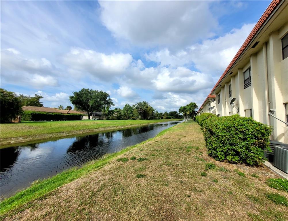 11096 Royal Palm Boulevard, Unit 11096 Coral Springs, FL 33065 - Photo 15 of 20 a view of a lake with a yard and large trees
