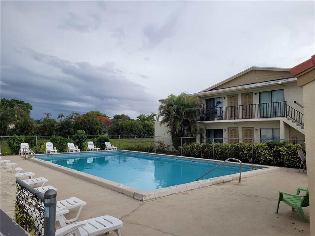 11096 Royal Palm Boulevard, Unit 11096 Coral Springs, FL 33065 - Photo 2 of 20 a view of a house with a swimming pool and a chairs