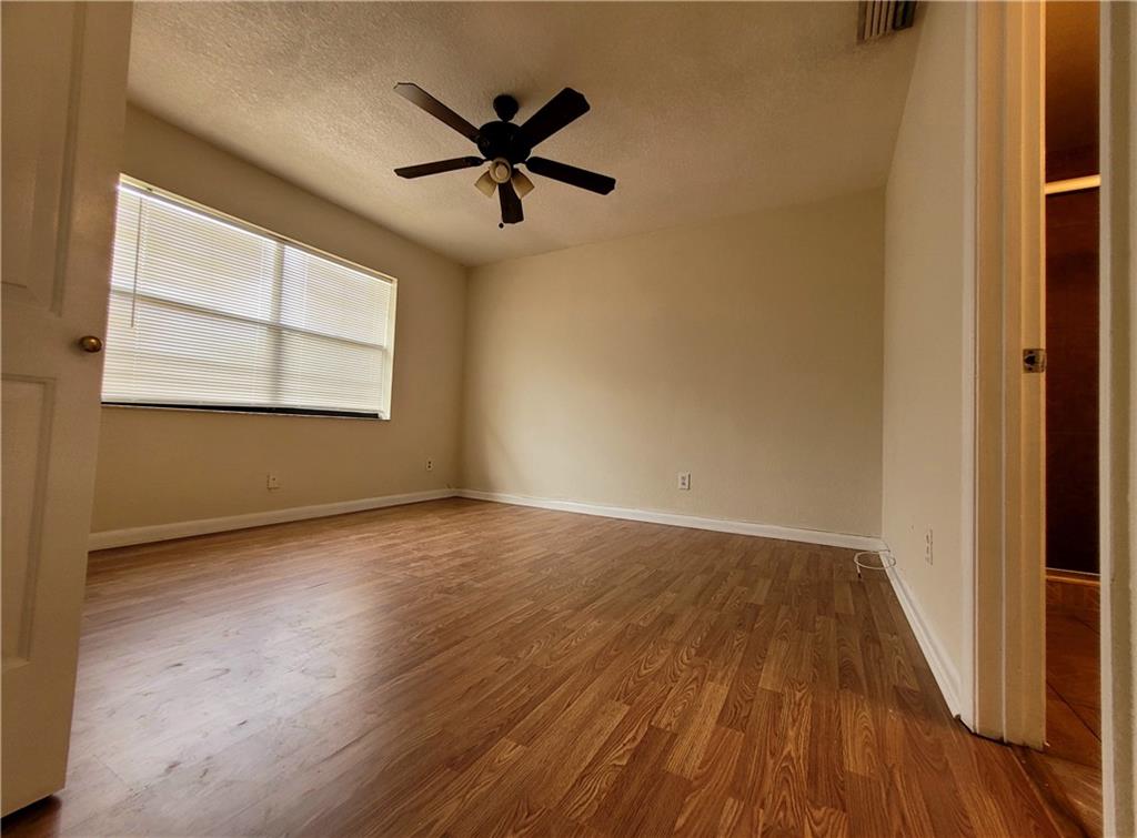 11096 Royal Palm Boulevard, Unit 11096 Coral Springs, FL 33065 - Photo 7 of 20 an empty room with wooden floor fan and windows