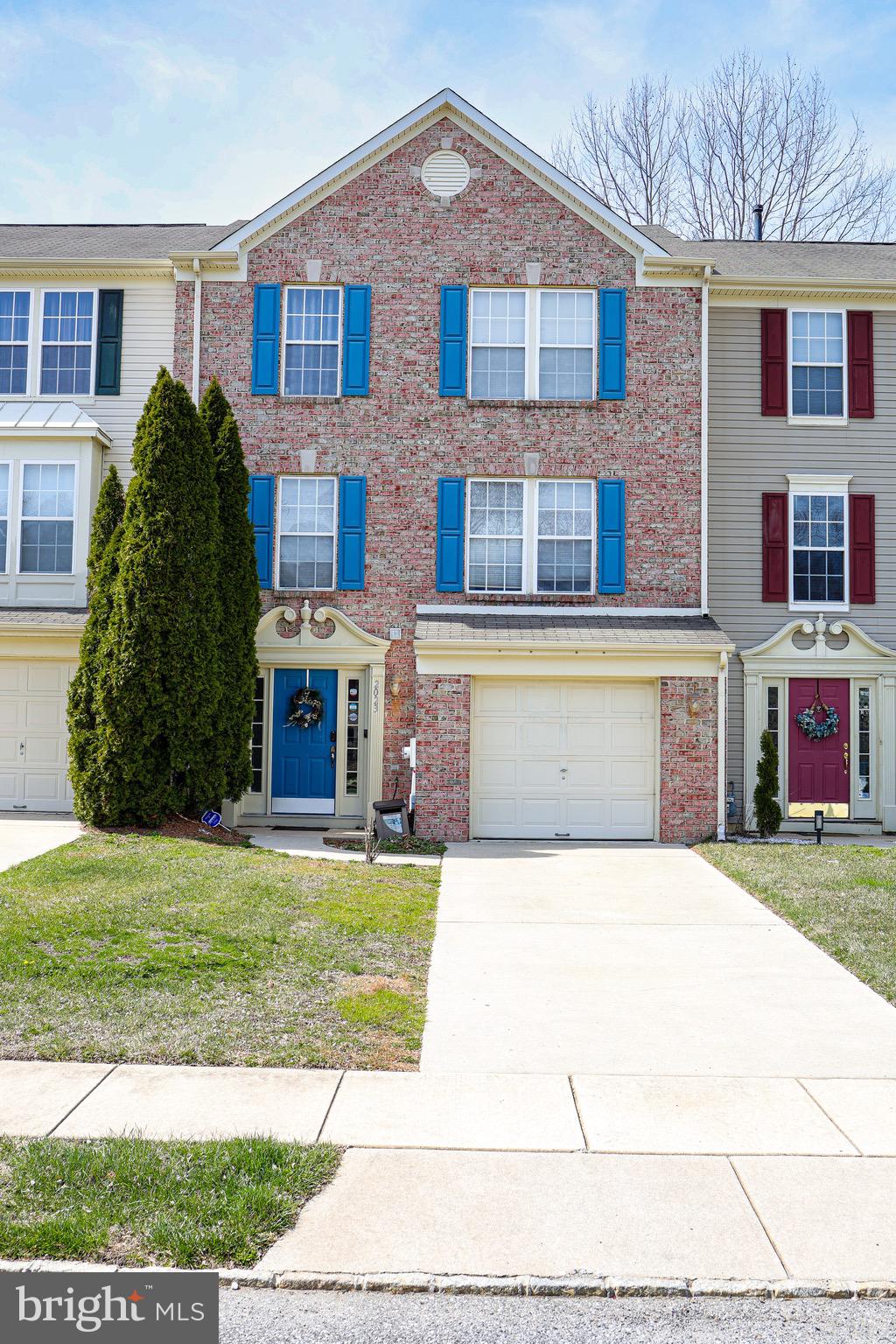 a front view of a house with a garden and trees