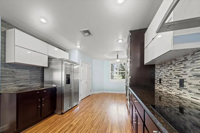 a kitchen with stainless steel appliances granite countertop a sink and wooden floor
