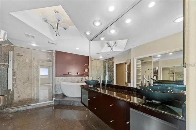 a spacious bathroom with a granite countertop sink a toilet a mirror and shower