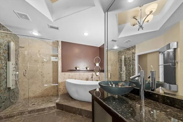 a kitchen with stainless steel appliances kitchen island granite countertop a refrigerator and a sink