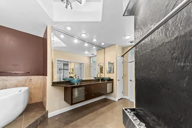 a bathroom with a tub a mirror and shower