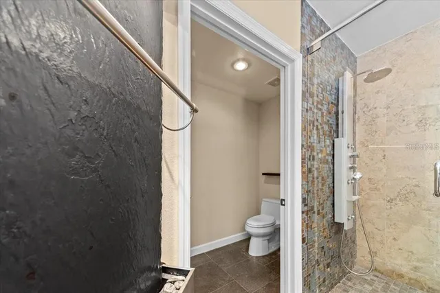 a large kitchen with a large counter top a sink stainless steel appliances and cabinets