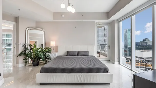 a bedroom with a large bed and a potted plant