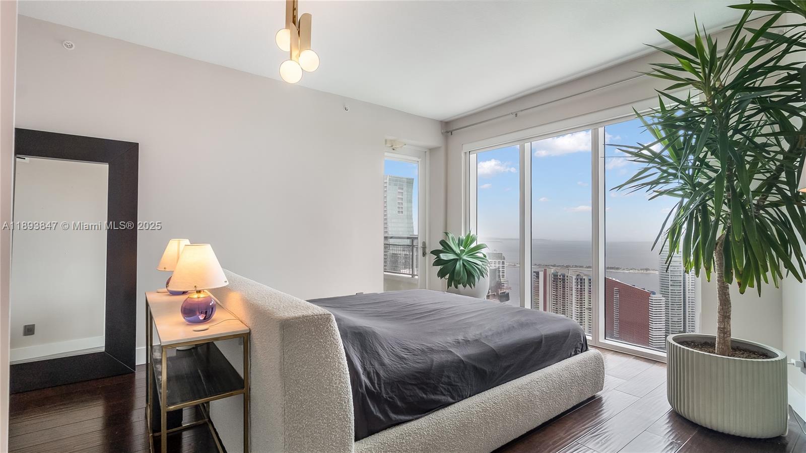 60 Southwest 13th Street, Unit 4200 Miami, FL 33130 - Photo 31 of 52 a spacious bedroom with a balcony a bed and a potted plant