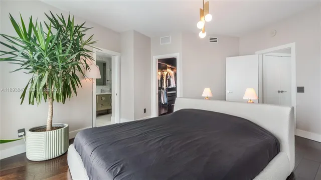 a bedroom with a bed and a potted plant