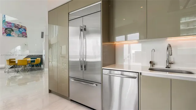 a kitchen with stainless steel appliances granite countertop a refrigerator and a sink