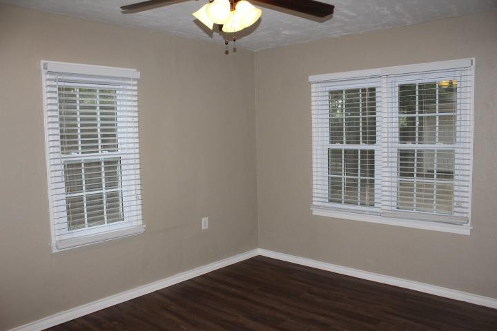 3111 30th Street Lubbock, TX 79410 - Photo 11 of 22 a view of an empty room with wooden floor and a window