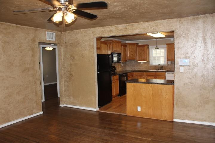 3111 30th Street Lubbock, TX 79410 - Photo 2 of 22 an empty room with wooden floor and a ceiling fan