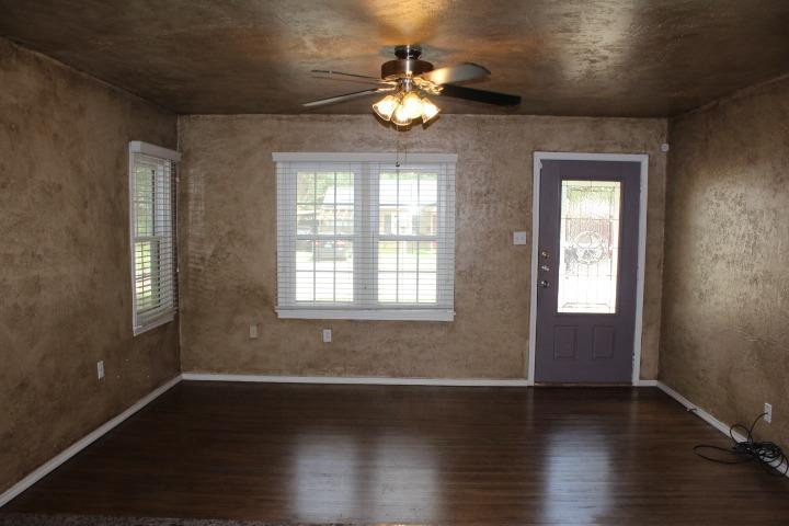 3111 30th Street Lubbock, TX 79410 - Photo 3 of 22 a view of an empty room with wooden floor and a window