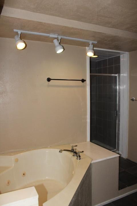 3111 30th Street Lubbock, TX 79410 - Photo 9 of 22 a bathroom with a bathtub and a shower