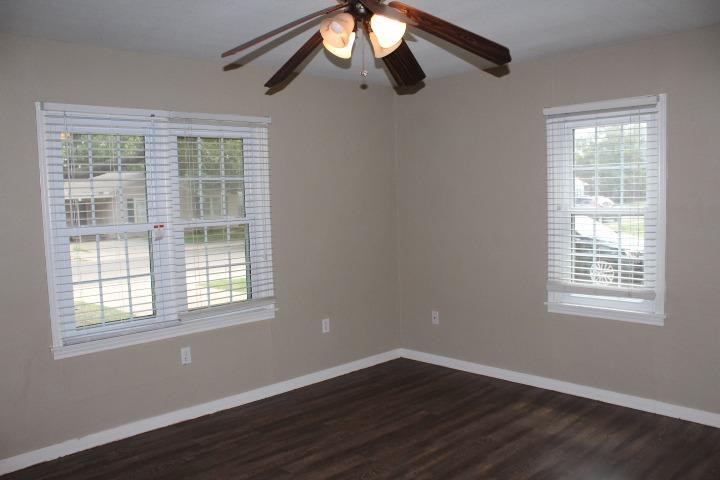 3111 30th Street Lubbock, TX 79410 - Photo 10 of 22 a view of an empty room with wooden floor and a window