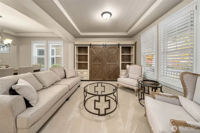 a living room with furniture and floor to ceiling windows