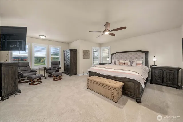 a spacious bedroom with a bed a couch and large window