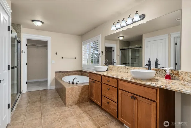 a spacious bathroom with a bathtub sink mirror and vanity