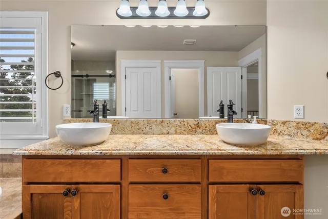 a bathroom with a granite countertop sink and a mirror