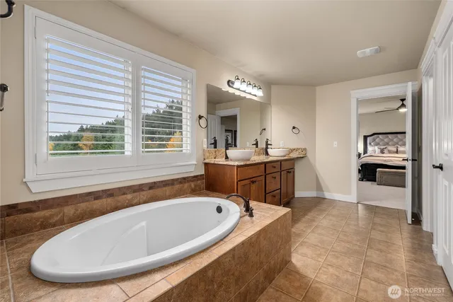 a bathroom with a tub sink and mirror