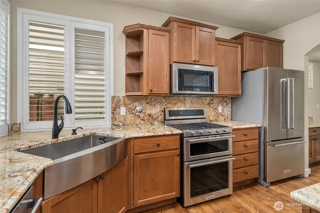 a kitchen with granite countertop a sink stove and refrigerator