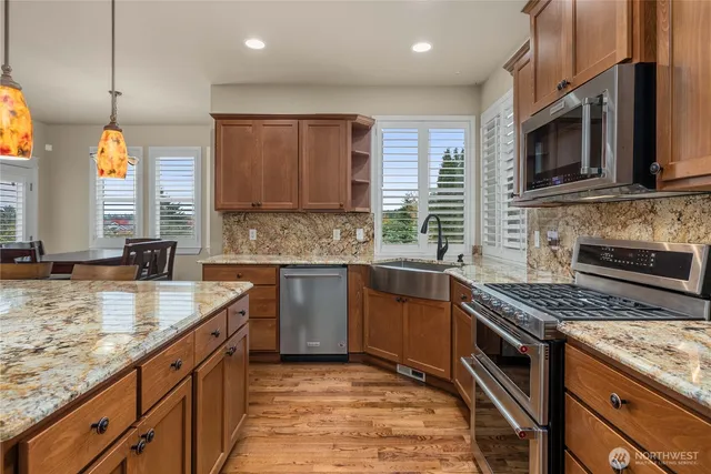 a kitchen with stainless steel appliances granite countertop a sink stove and microwave