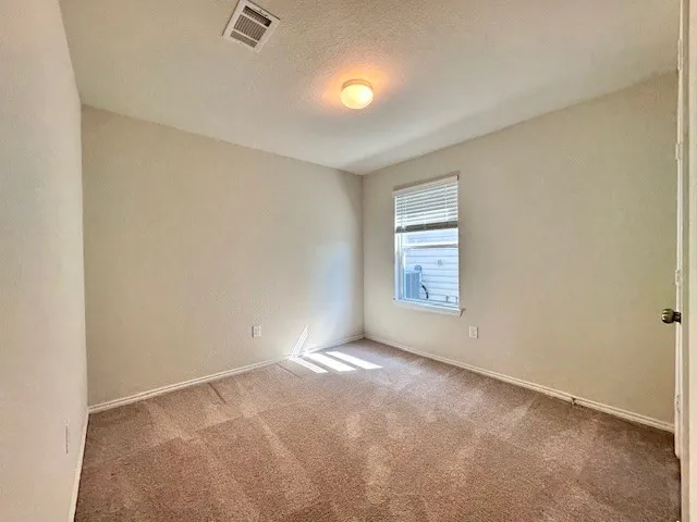a view of an empty room with a window and closet area