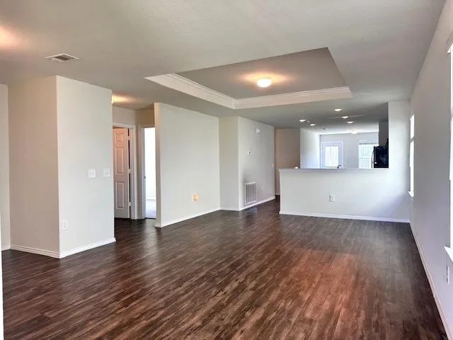 a view of a big room with wooden floor and a kitchen