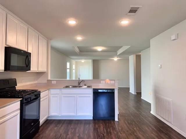 a kitchen with kitchen island granite countertop a sink and cabinets