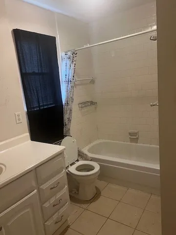 a bedroom with a bed lamp and a window