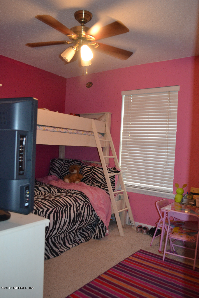 12058 Spring Ridge Drive Jacksonville, FL 32258 - Photo 7 of 9 a bedroom with a bed and chair