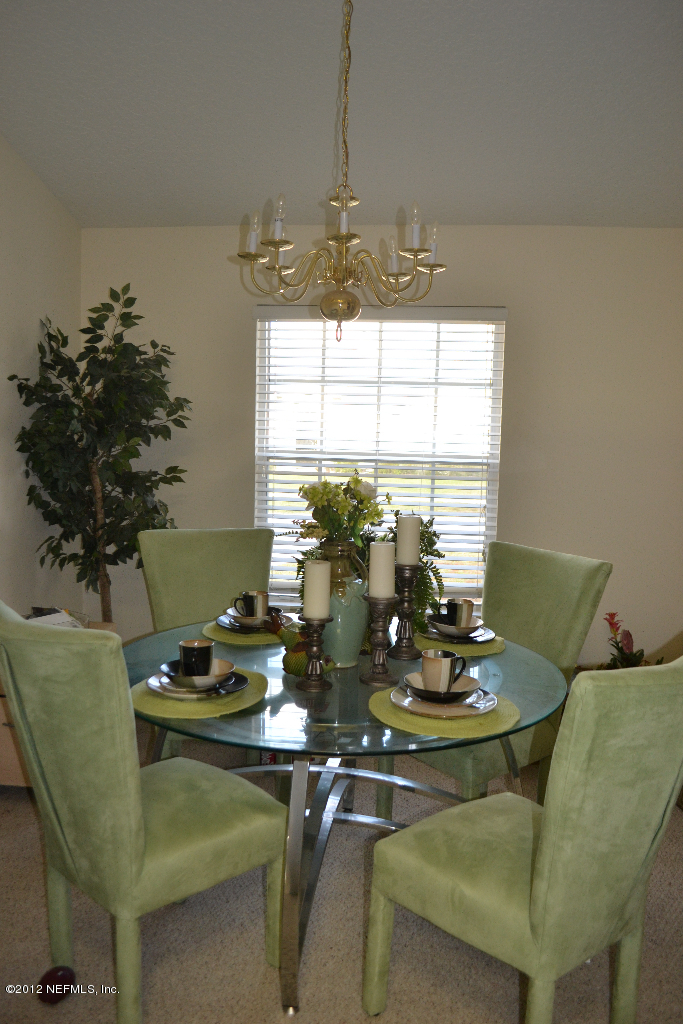 12058 Spring Ridge Drive Jacksonville, FL 32258 - Photo 9 of 9 a kitchen with a table and a chandelier